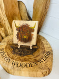 Highland cow laser engraved and hand painted onto a lovely piece of oak with stand