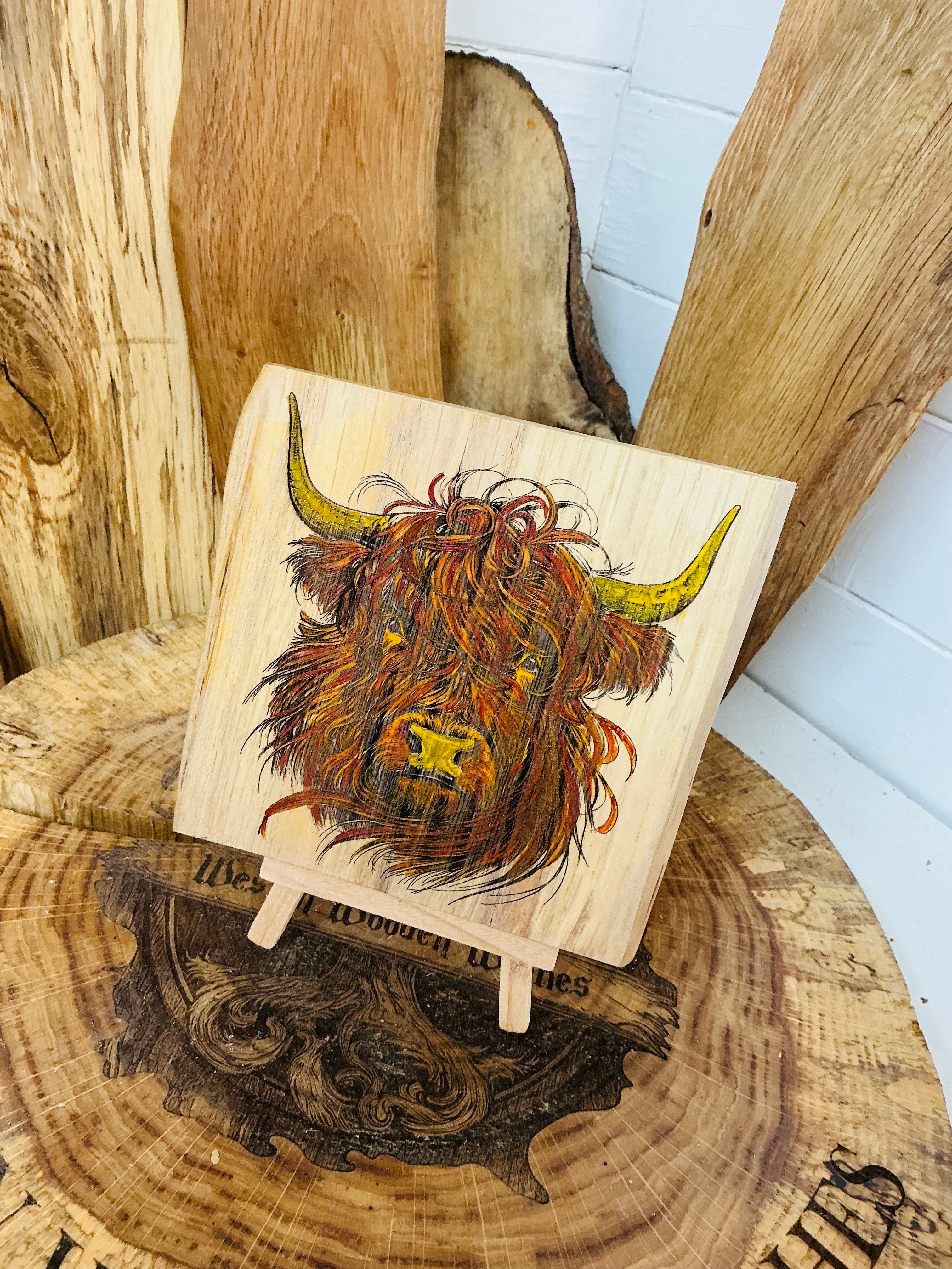 Highland cow laser engraved and hand painted onto a lovely piece of oak with stand